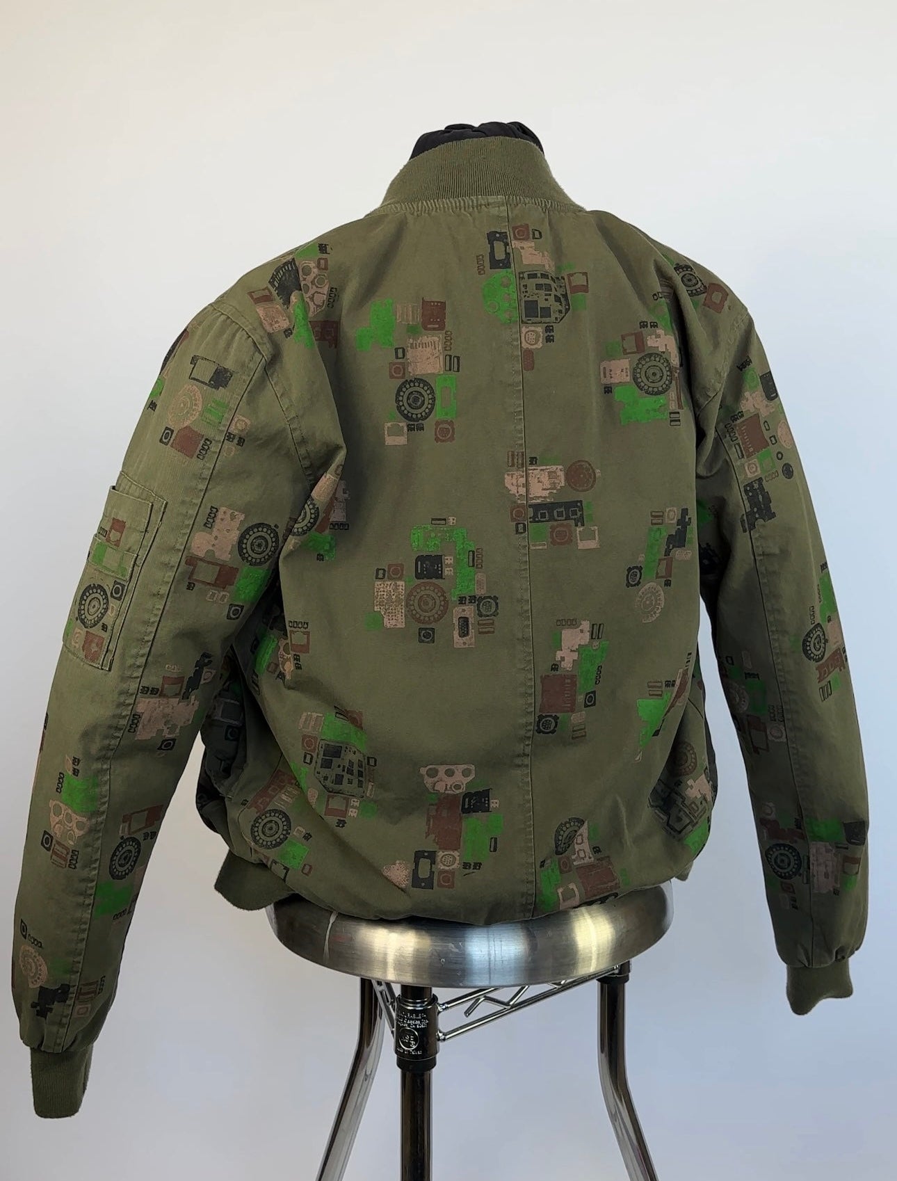 Green camouflage jacket on a mannequin against a white background